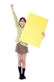 Biracial asian girl in green sweater holidng blank yellow sign, arm cheering in air