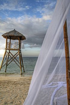 Tropical watchtower overlooking a beach wedding set up
