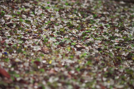 hundreds of glass and rock pebbles in a sidewalk flower bed.