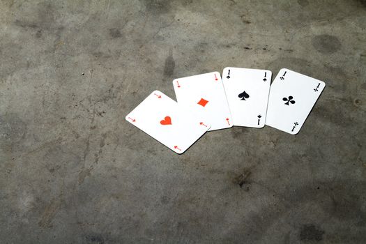 four aces on a cement floor