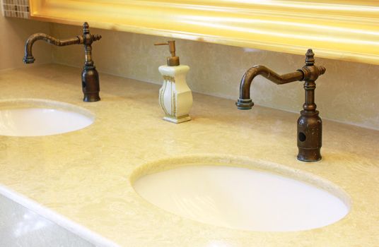 Sinks and taps with hand soap in a public toilet