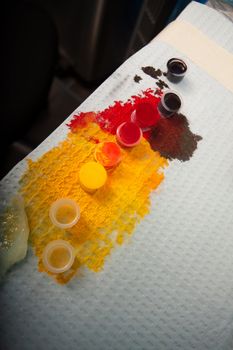Various colorful inks spilled on table in tattoo parlor