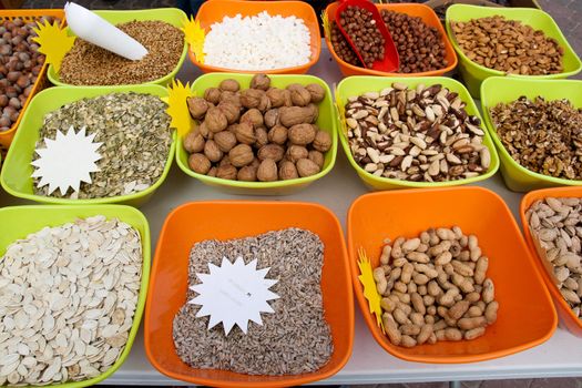 Nuts and seeds in colored containers for sale on the market