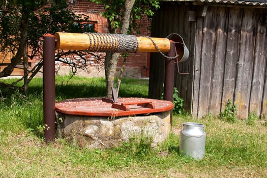 vintage water well and milk canister in the countryside