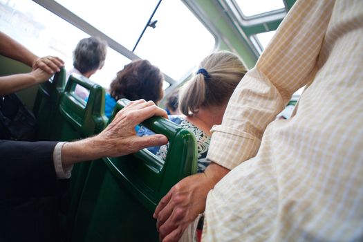 Hand of an elderly person touch the chair