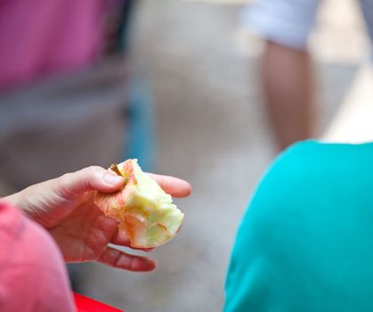 Female holding a red bitten apple