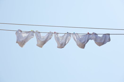 White underpants hanging to dry on a clothes-line.