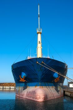 Medium size cargo container ship in the harbor port in frontal view