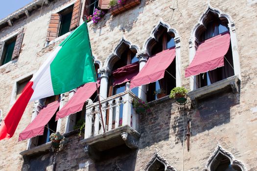 Italian flag flies over a balcony in Venice