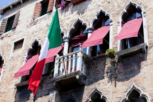 Italian flag flies over a balcony in Venice