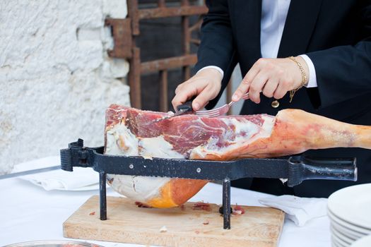 Waiter while slicing jamon, the spanish ham