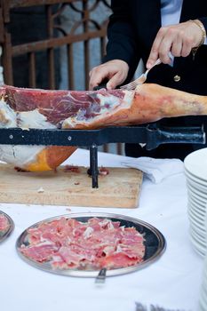 Waiter while slicing jamon, the spanish ham