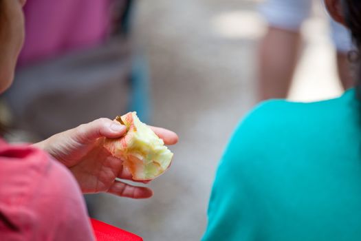 Female holding a red bitten apple