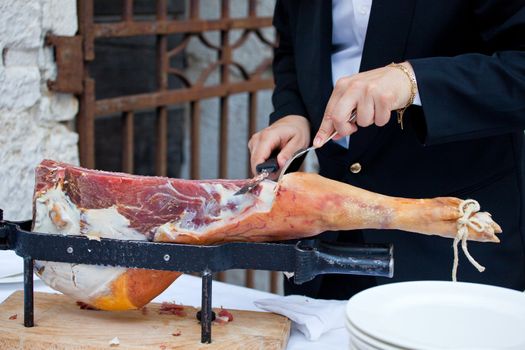 Waiter while slicing jamon, the spanish ham