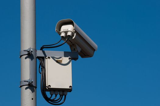 security / surveillance camera against a clear blue sky