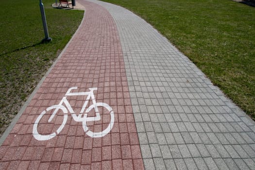 bicycling path with bike sign on a brick pavement