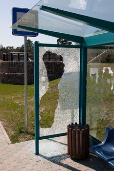Damaged glass at a bus stop shed
