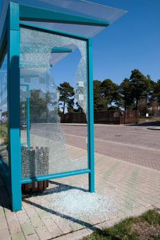 Damaged glass at a bus stop shed