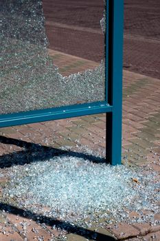 Damaged glass at a bus stop shed