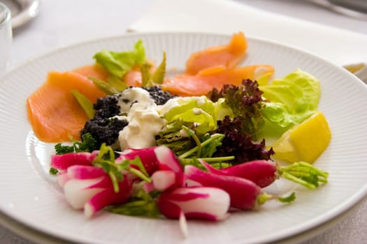 Smoked salmon with salad in a white plate