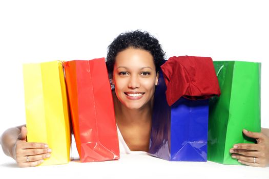 Smiling woman with colorful shopping bags isolated on white