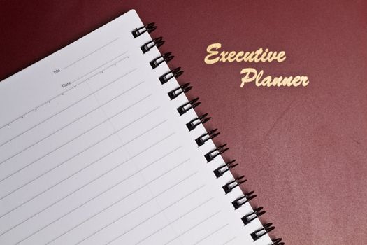 a dark red executive planner with spiral note book in lanscape orientation