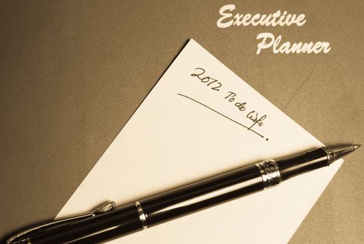 executive planner with yellow note pad and a pen in lanscape orientation in retro colors