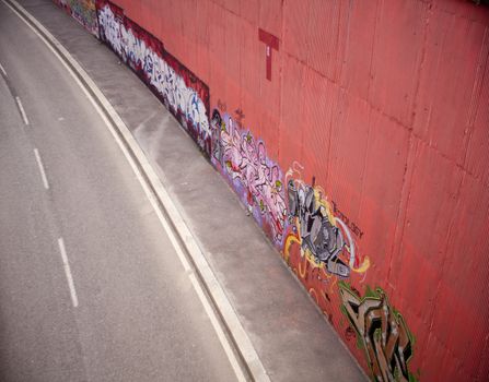 View of a road with graffiti on the wall