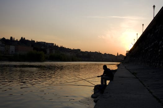 Fisherman at sunset, Arno river in Florence - Italy