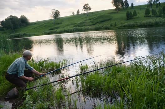 The fisherman catches a fish in the river in the spring