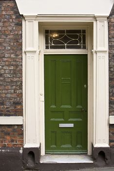 Green wooden door part of a building or home in London, England