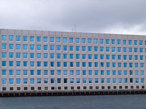 Corporate modern office building facade by a river canal