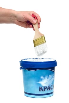 The hand holding a brush with a white paint