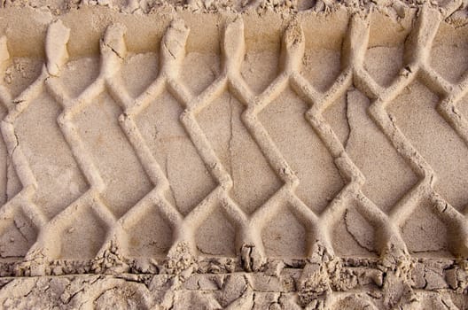 industrial car tyre traces on sand background