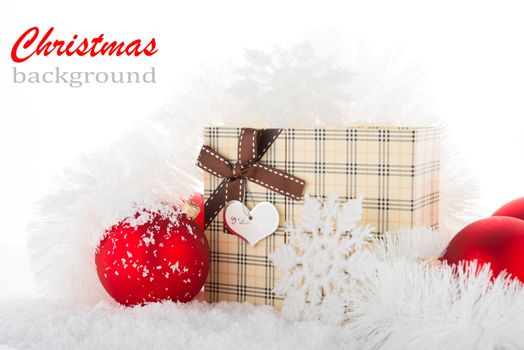 Gift box and Christmas tree decorations on a snow.
