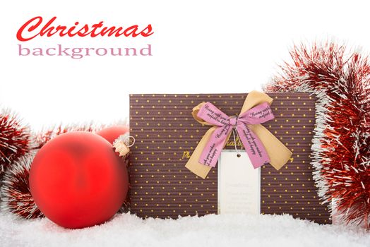 Gift box and Christmas tree decorations on a snow.