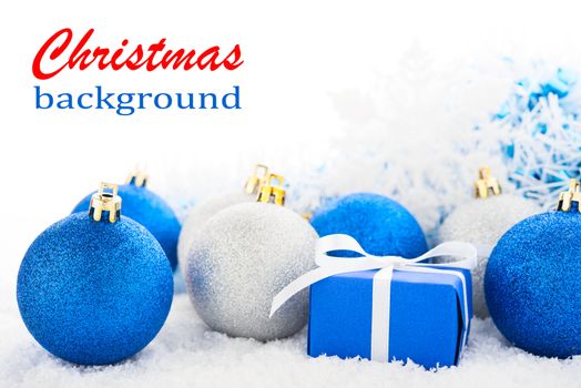 Gift box and Christmas tree decorations on a snow.