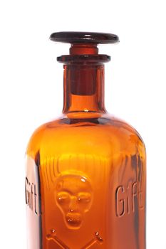 Old fashioned brown glass poison bottle with a stopper and an embossed skull and crossbones warning of the danger and toxicity of the contents
