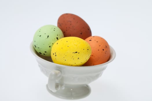 Colorful easter eggs in white cup