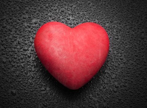 Red heart on wooden background with raindrops