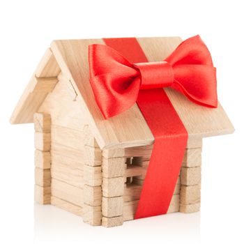 Small wooden house with red bow and ribbon