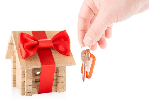 Concept of Hand with keys and wooden house