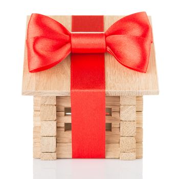 Small wooden house with red bow and ribbon