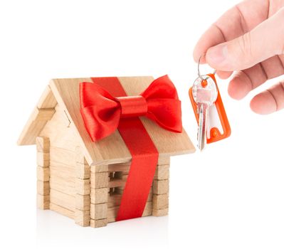 Concept of Hand with keys and wooden house