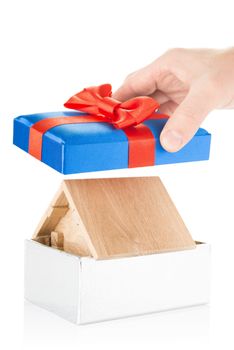 Small wooden house in a gift box with red bow