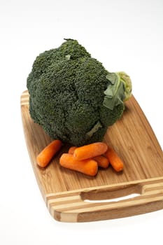 brocolli and carrots on the cutting board on the white background 