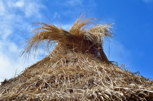 Straw parasol on the background of blue sky