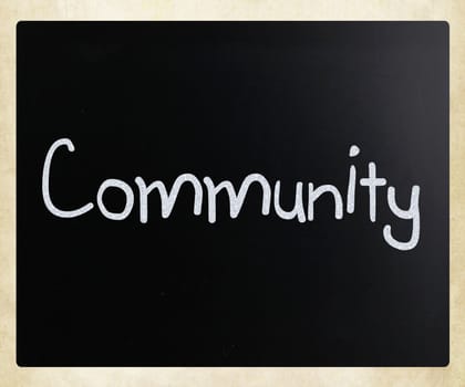 "Community" handwritten with white chalk on a blackboard