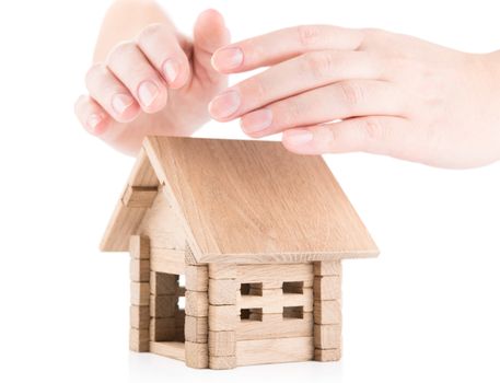 Woman hands protecting small wooden  house