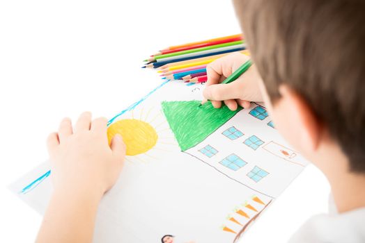Child drawing a home with pencil
